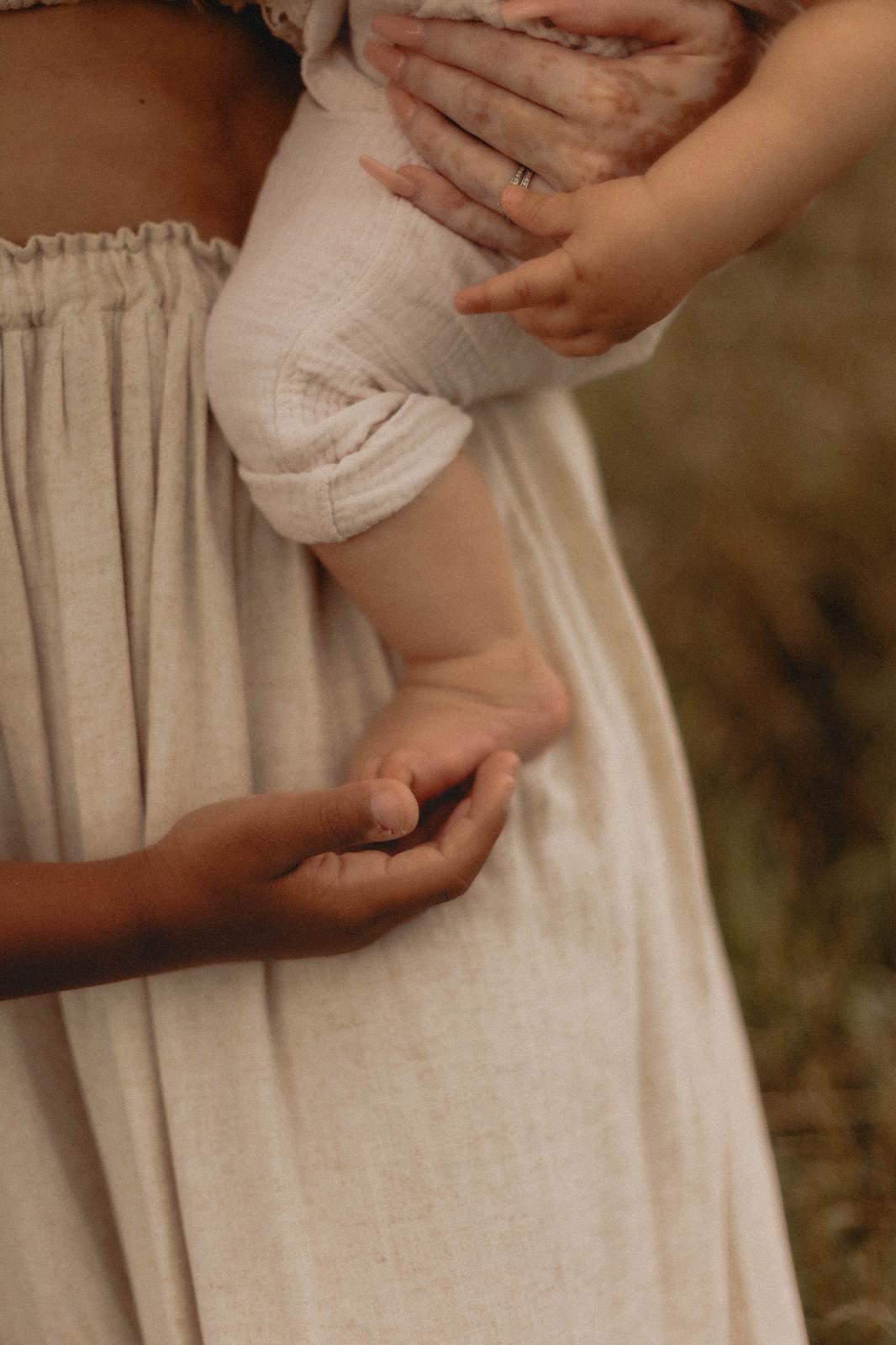 Detailaufnahme – Babyfüßchen und liebevolle Mutterhand