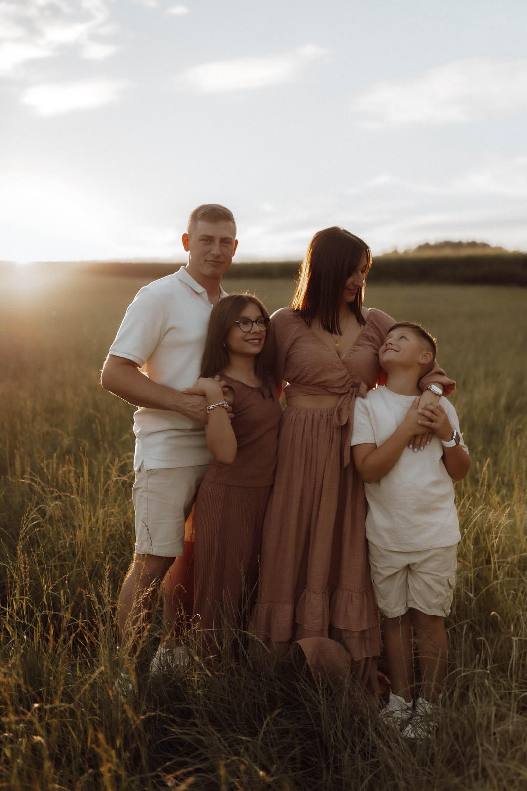 Familie mit Kindern auf einem Feld im goldenen Abendlicht