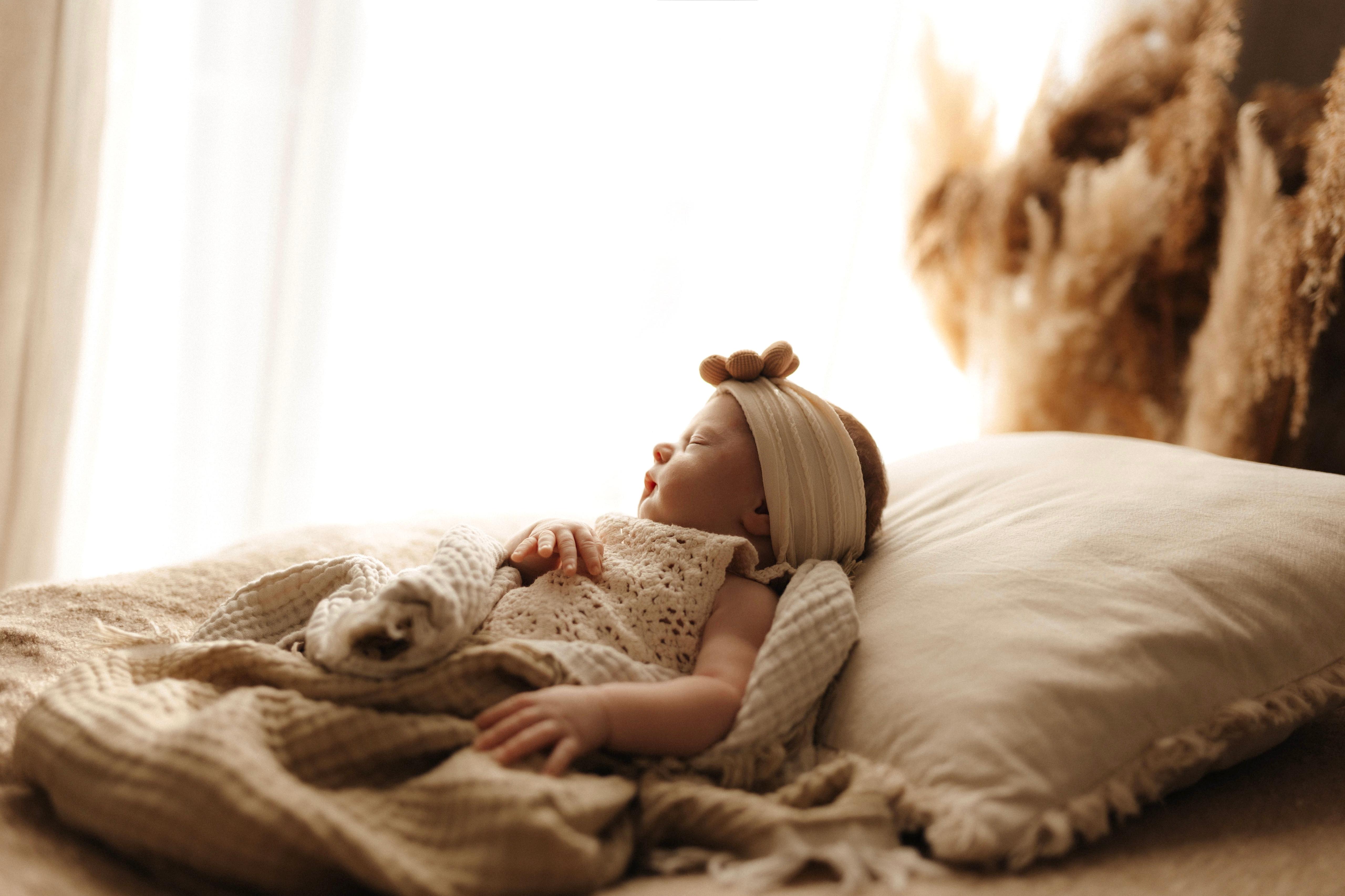 Junge Eltern betrachten liebevoll ihr Neugeborenes am Fenster – Newborn-Shooting von Simple Moments